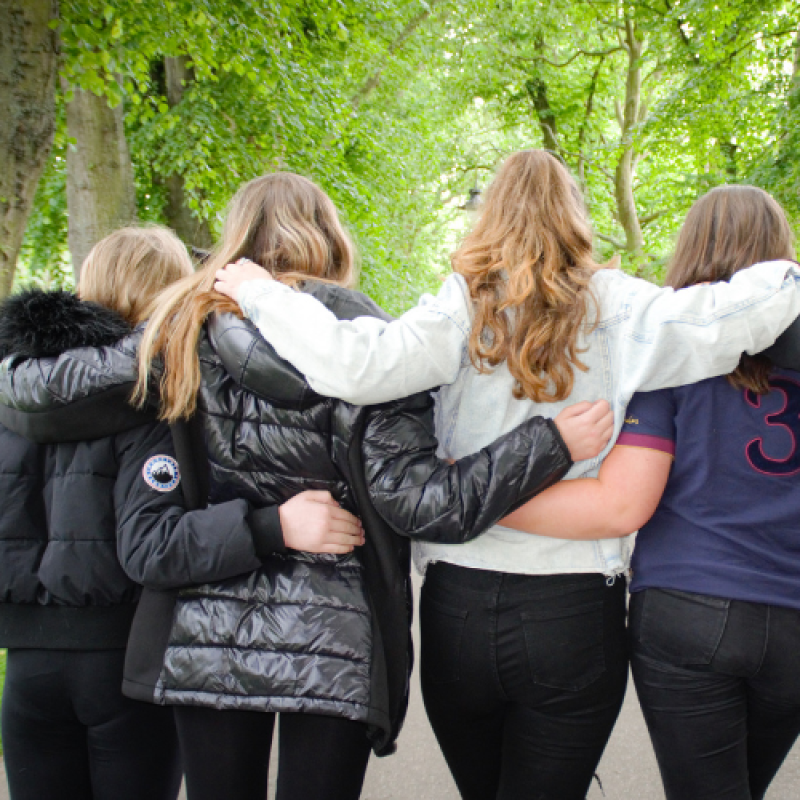 Group of young people who were bereaved of a parent who served in the British Armed Forces with arms around each other