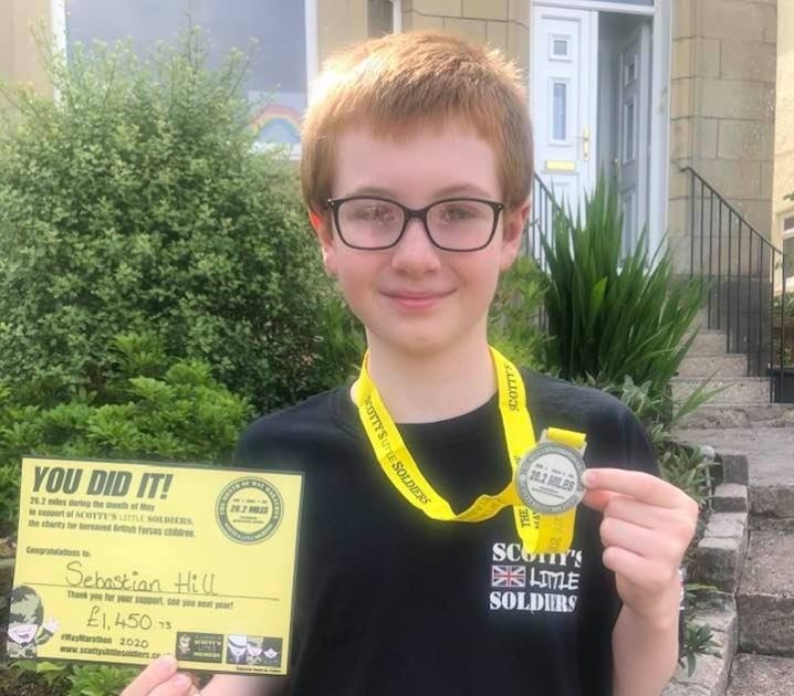 Sebastian Hill holding his May Marathon medal