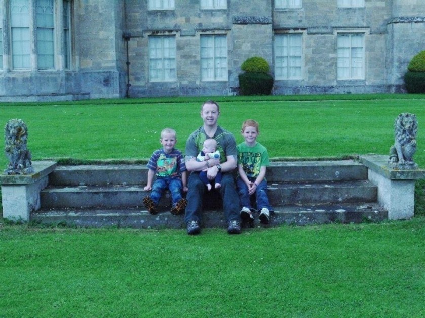 Ian sat in the countryside with his children