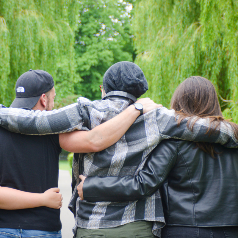 Springboarders and bereaved military children supporting each other with arms around each other in park